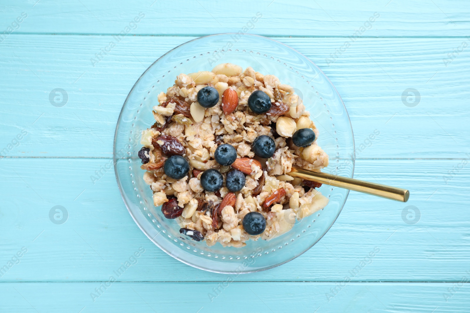 Photo of Tasty muesli with blueberries on light blue wooden table, top view. Healthy breakfast
