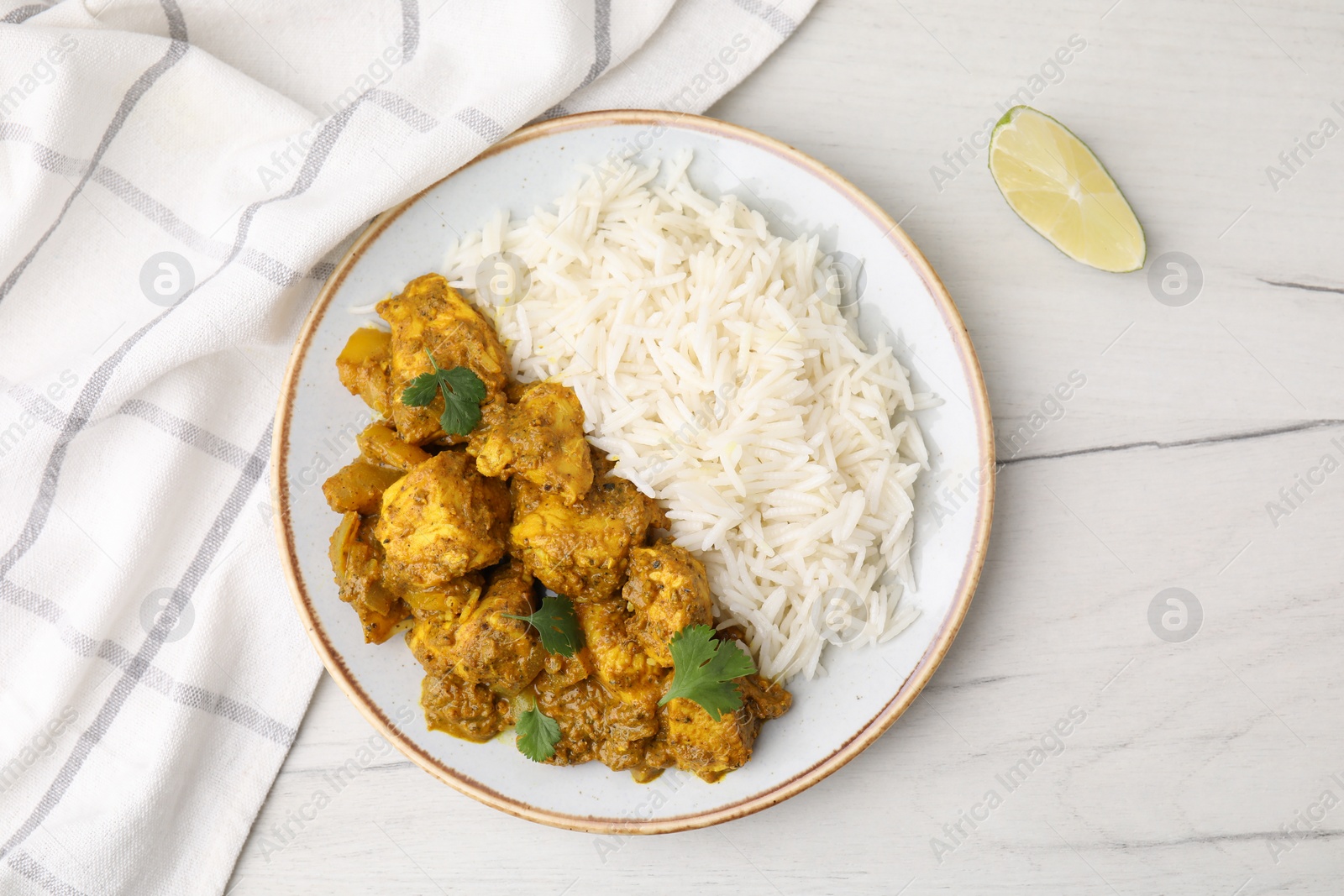 Photo of Delicious chicken curry with rice on white wooden table, top view