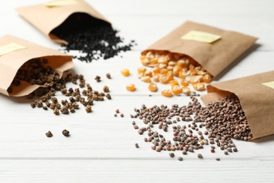 Different vegetable seeds on white wooden table