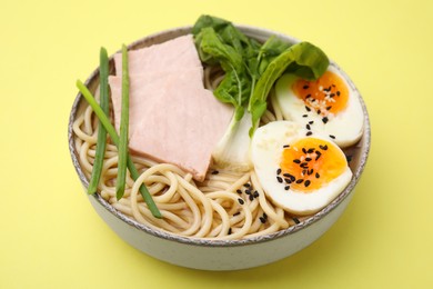 Photo of Delicious ramen with meat on pale yellow background, closeup. Noodle soup