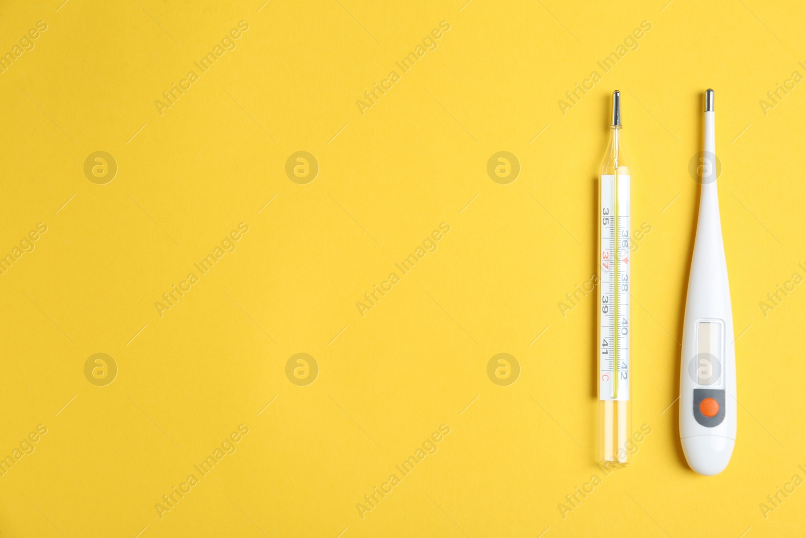 Photo of Different thermometers on yellow background, flat lay. Space for text