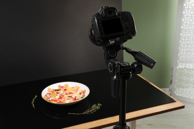 Professional camera and salad with prosciutto in photo studio. Food photography