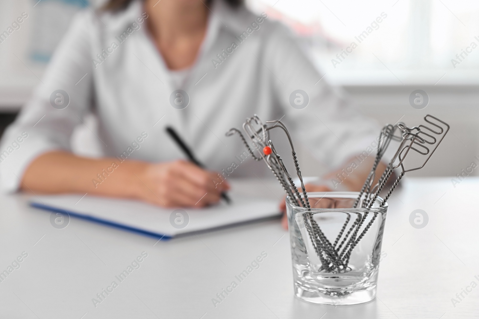 Photo of Set of different logopedic probes in holder on light table, space for text. Speech therapist's tools