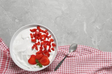 Photo of Delicious yogurt with strawberries served on grey marble table, flat lay. Space for text