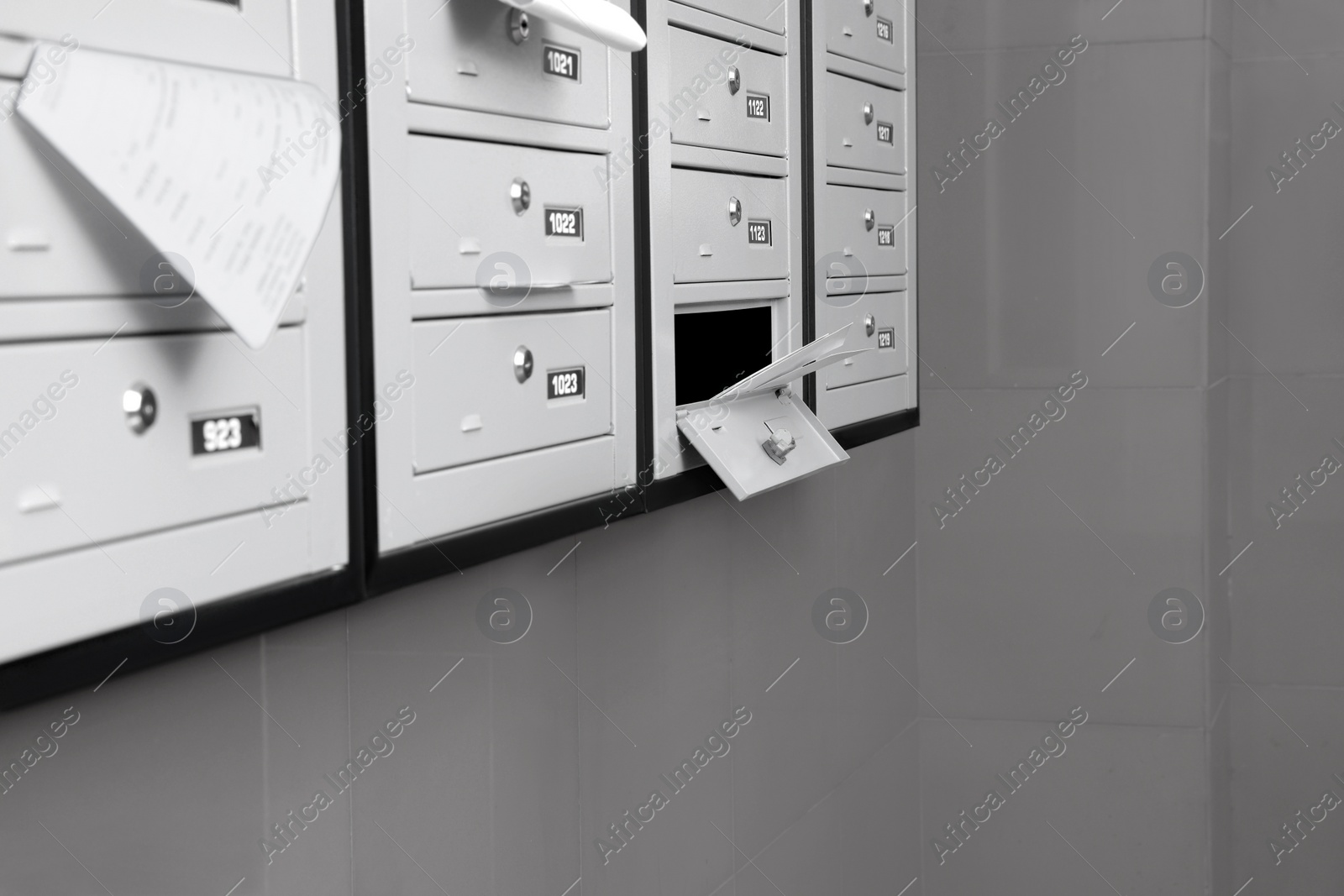 Photo of Closed grey metal mailboxes with receipts indoors