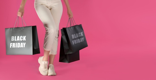 Photo of Woman with shopping bags on pink background, closeup. Black Friday Sale