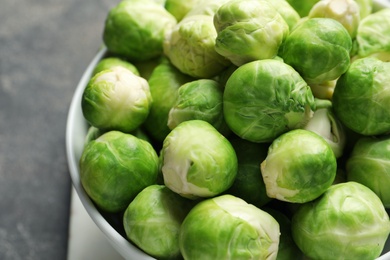 Photo of Bowl of fresh Brussels sprouts on table, closeup
