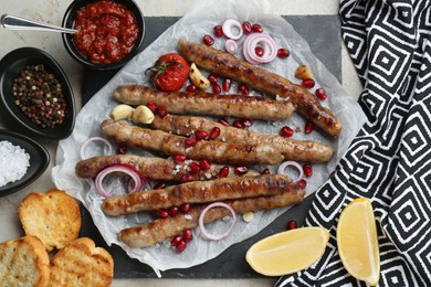 Photo of Tasty grilled sausages served on light table, flat lay