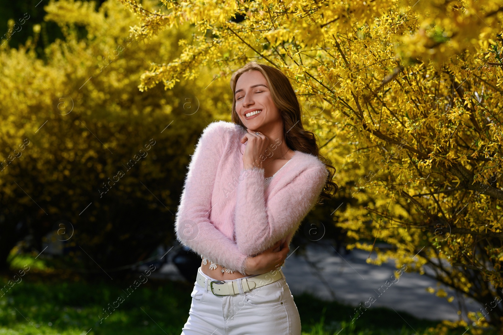 Photo of Beautiful young woman near blossoming shrub on spring day