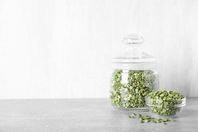 Dried peas in glass jar on grey table, space for text