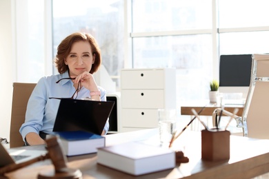 Photo of Female lawyer working at table in office