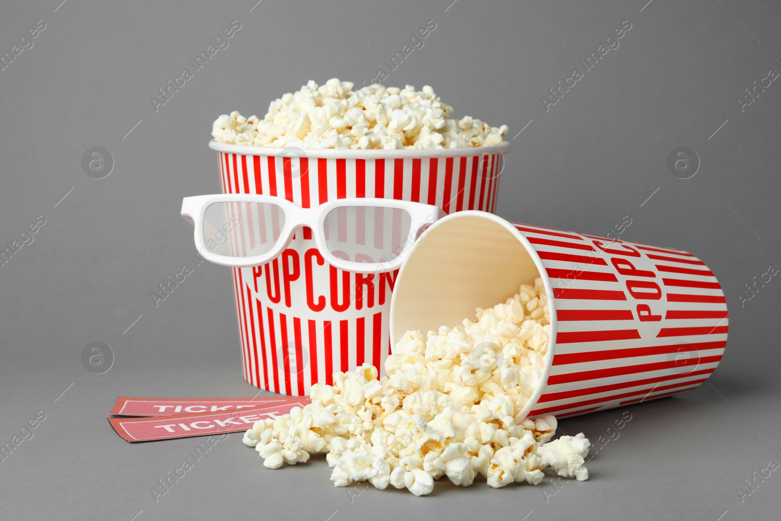 Photo of Popcorn, cinema tickets and 3d glasses on grey background