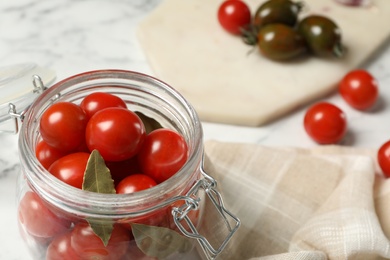 Photo of Pickling jar with fresh ripe cherry tomatoes on table, closeup. Space for text