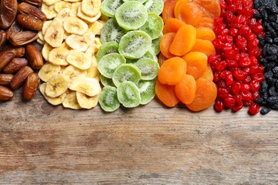 Photo of Different dried fruits on wooden background, top view with space for text. Healthy lifestyle