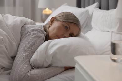 Photo of Menopause, sleep problems. Woman suffering from insomnia in bed indoors
