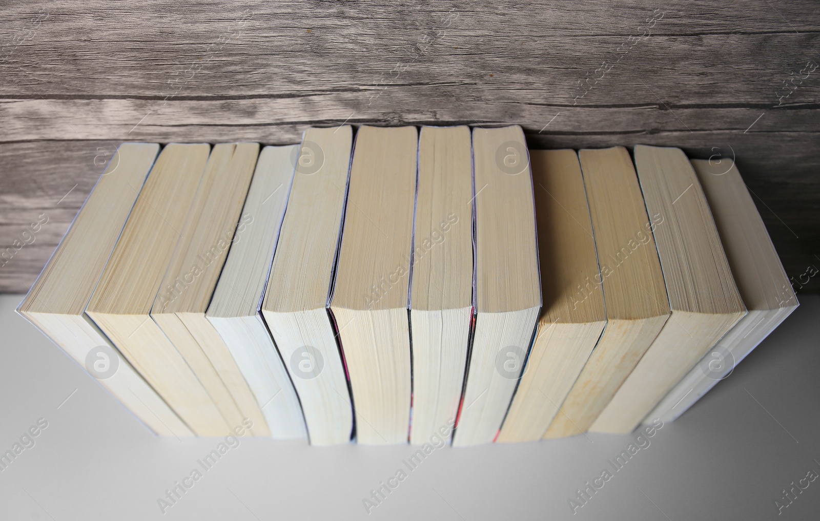 Photo of Collection of different books on white shelf, above view