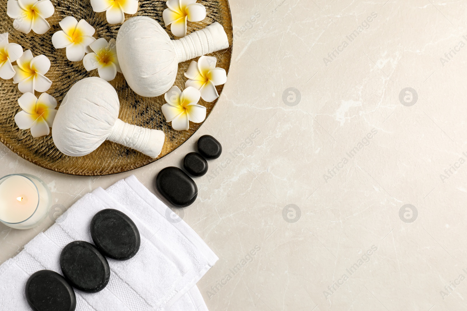 Photo of Spa bags, stones and orchid flowers on beige marble table, flat lay. Space for text