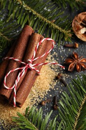 Photo of Different aromatic spices and fir branches on grey table, flat lay