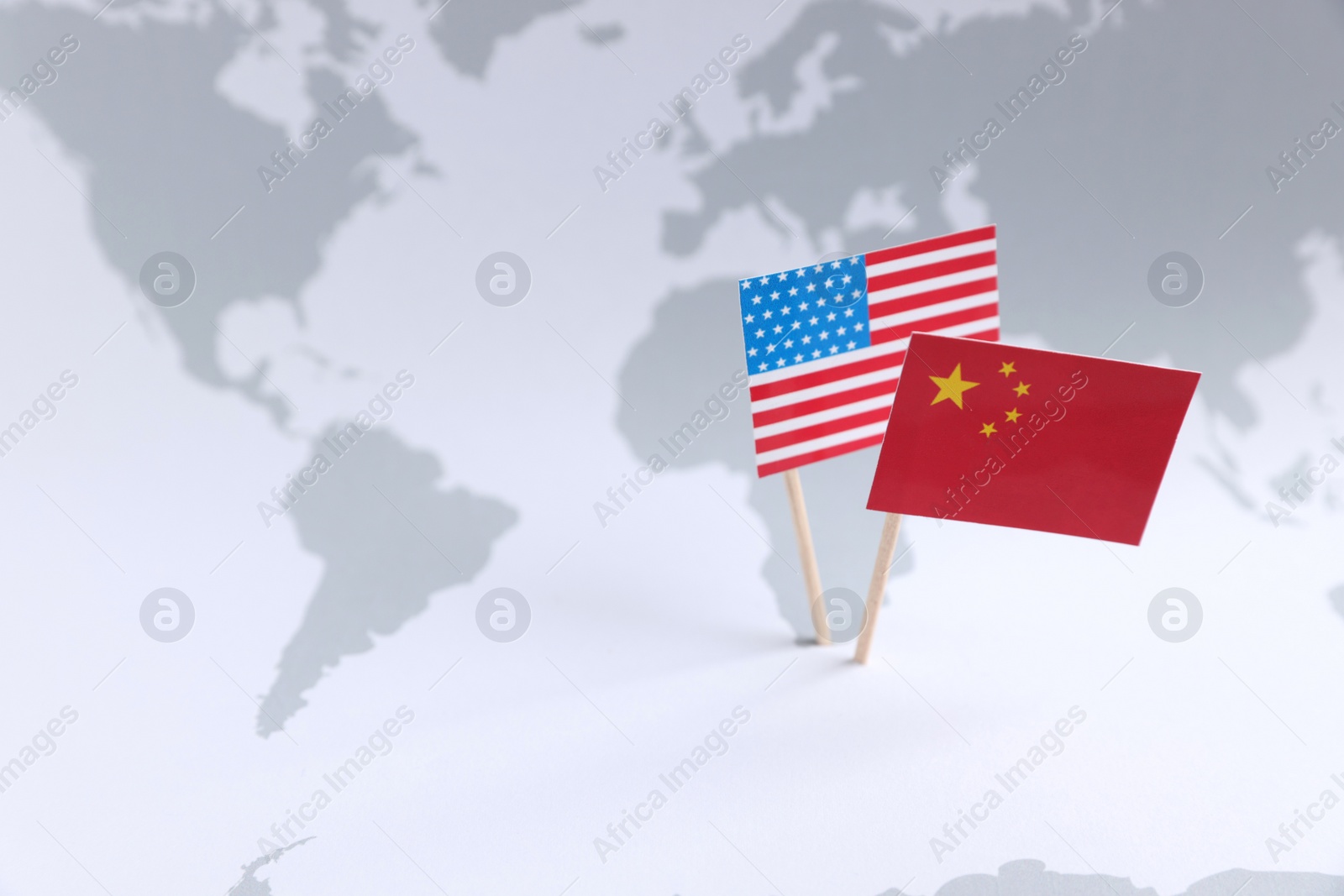 Photo of American and Chinese flags on world map, space for text. Trade war concept