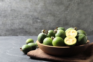 Photo of Delicious fresh feijoas on black table, space for text