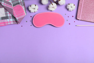 Photo of Flat lay composition with sleeping mask on violet background, space for text. Bedtime accessory