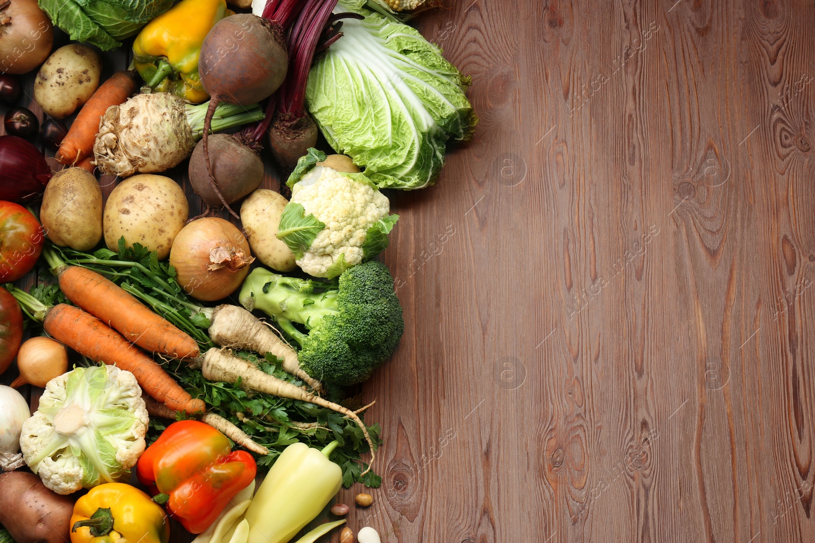 Photo of Different fresh vegetables on wooden table, flat lay with space for text. Farmer harvesting