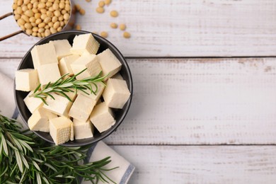 Photo of Delicious tofu cheese, rosemary and soybeans on white wooden table, flat lay. Space for text