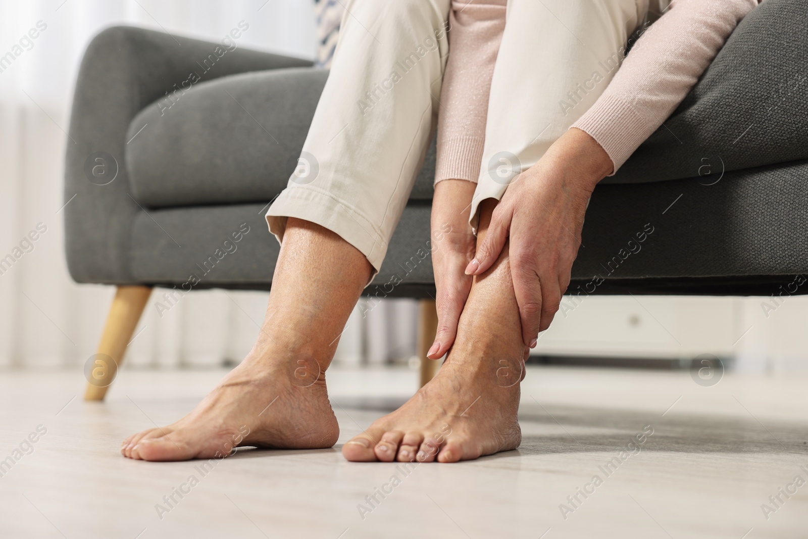 Photo of Arthritis symptoms. Woman suffering from pain in leg at home, closeup