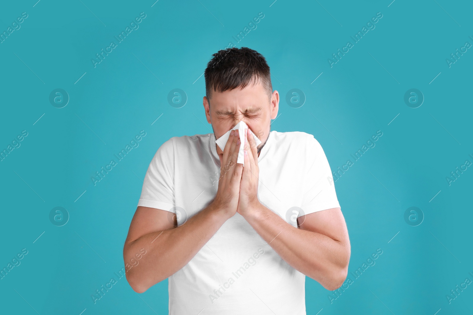 Photo of Man suffering from allergy on blue background
