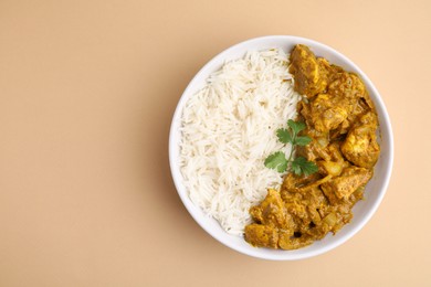 Photo of Delicious chicken curry with rice on beige background, top view. Space for text