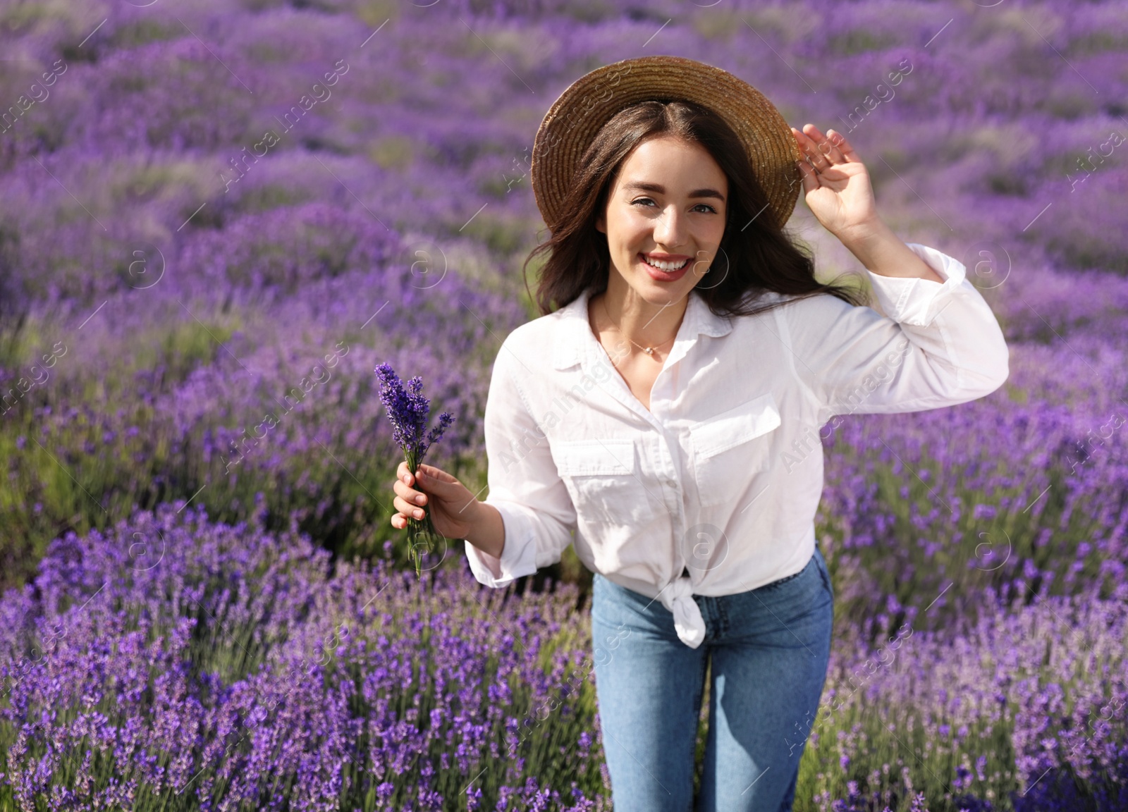 Photo of Young woman with lavender bouquet in field on summer day