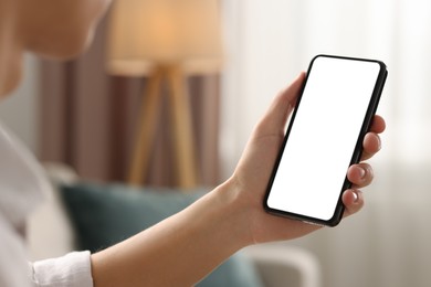 Photo of Man using smartphone with blank screen indoors, closeup. Mockup for design