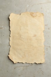 Sheet of old parchment paper on grey table, top view