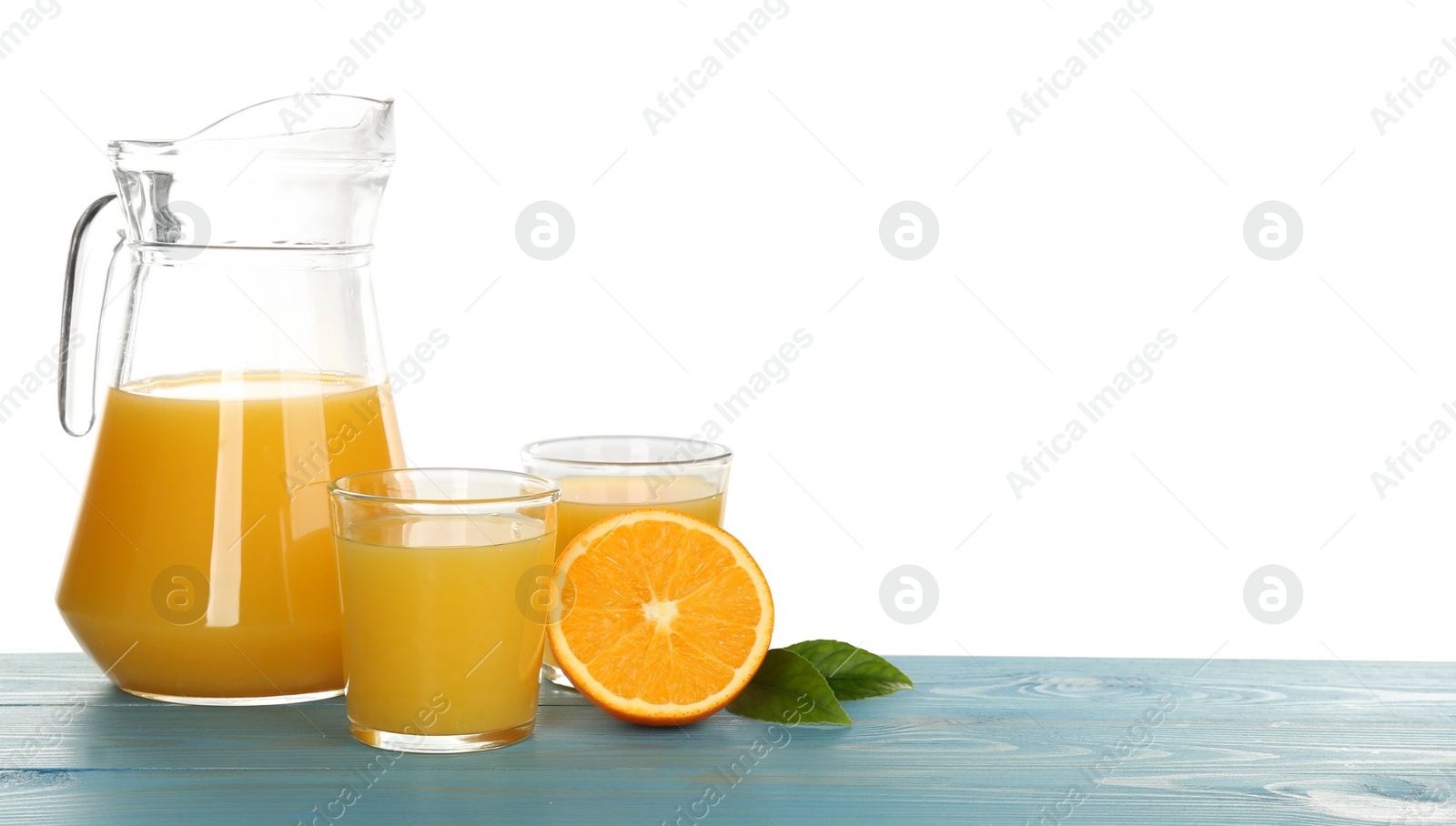 Photo of Delicious orange juice and fresh fruit on light blue wooden table against white background. Space for text