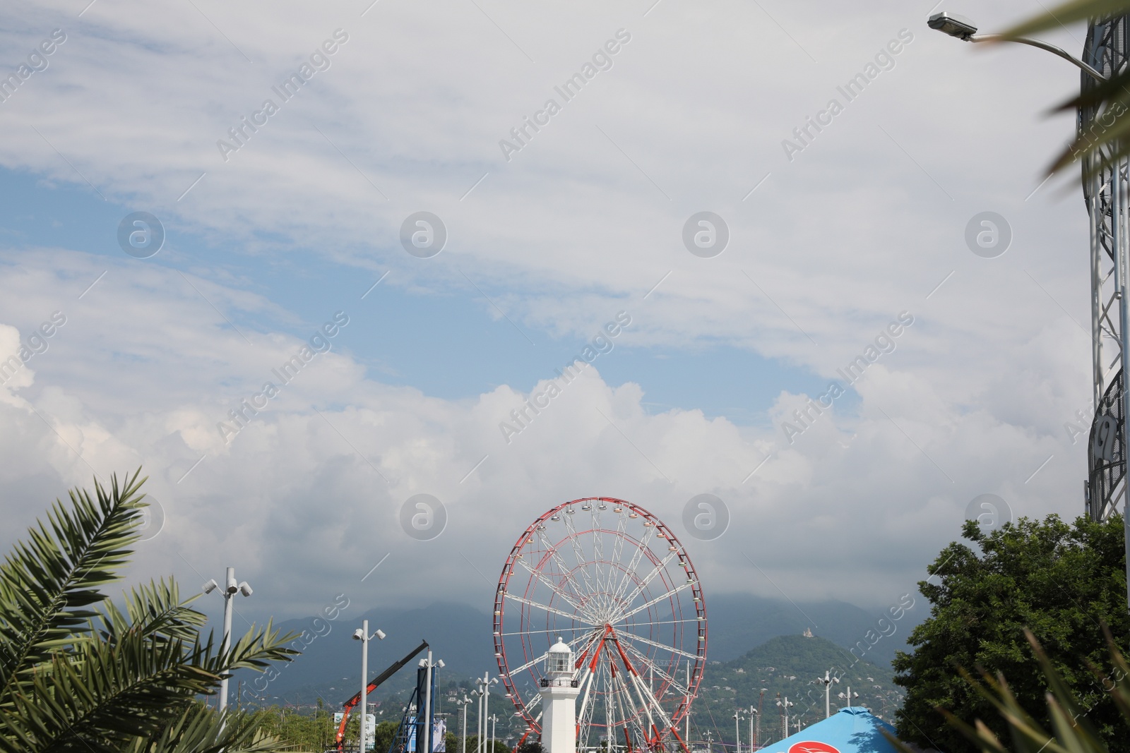 Photo of BATUMI, GEORGIA - JUNE 14, 2022: Beautiful landscape with Ferris wheel against cloudy sky