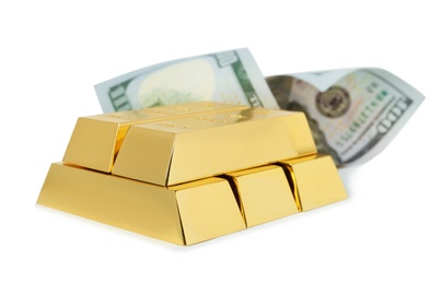 Photo of Shiny gold bars and dollar bill on white background