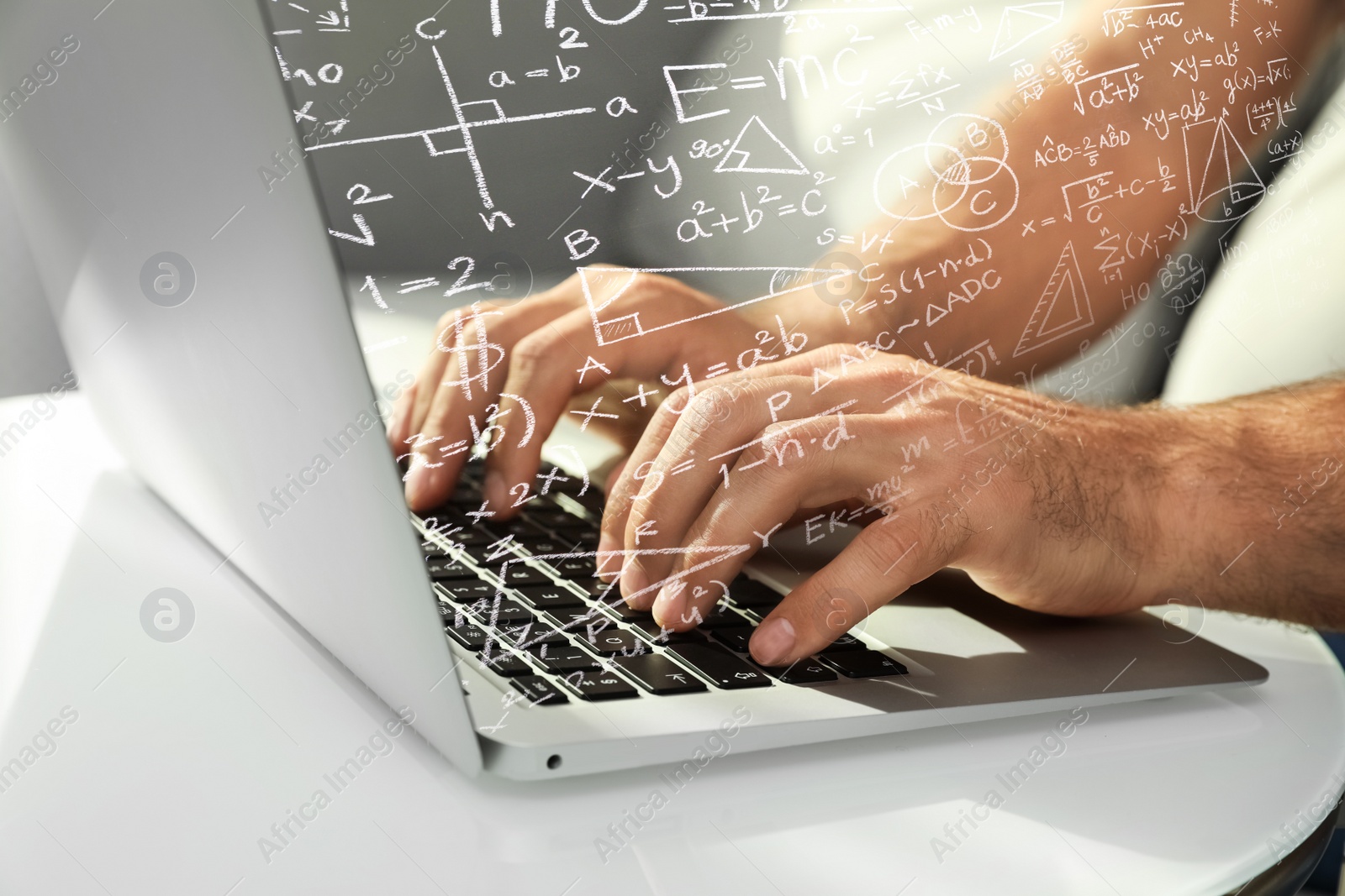 Image of Science and education concept. Illustration of basic physics and mathematics formulas and man working on laptop at table, closeup