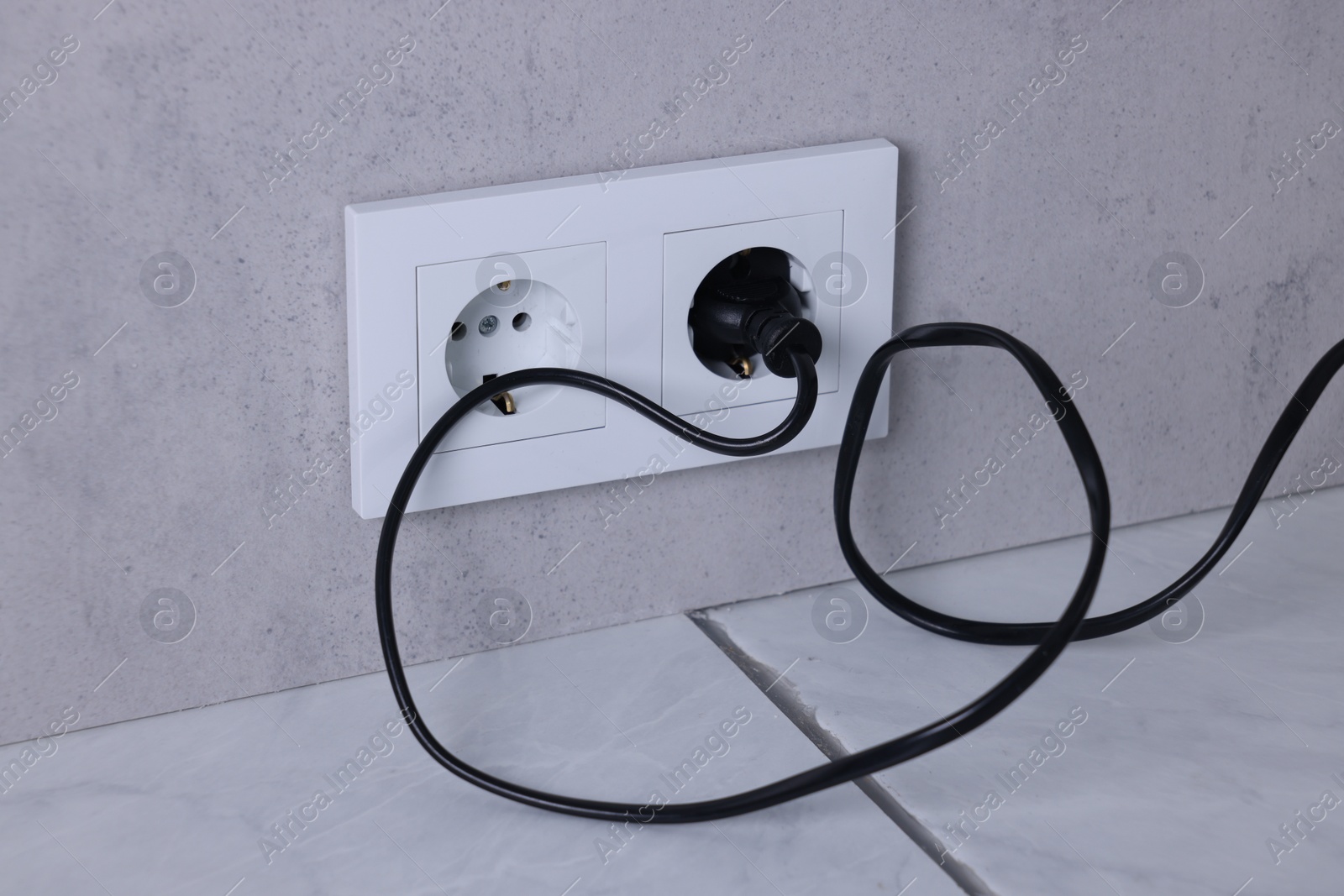 Photo of Power sockets and electric plug on grey wall