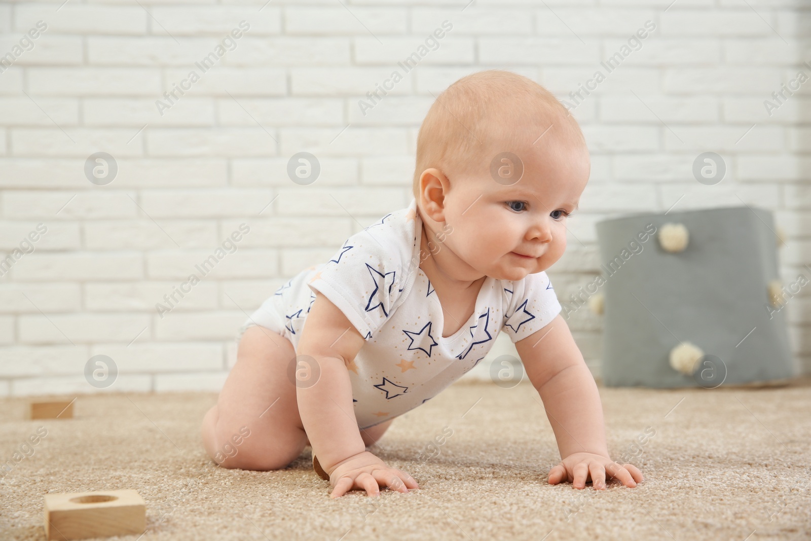 Photo of Cute little baby crawling on carpet indoors