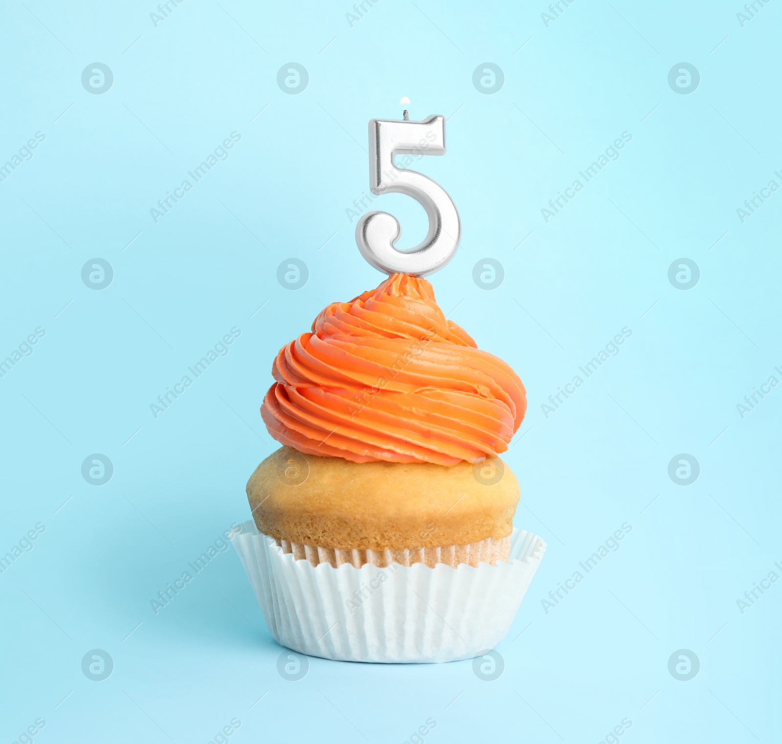 Photo of Birthday cupcake with number five candle on blue background