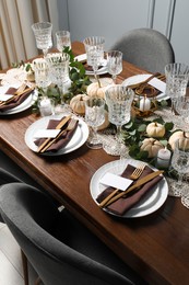 Photo of Beautiful autumn table setting. Plates, cutlery, glasses, blank cards and floral decor