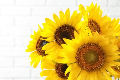 Bouquet of beautiful yellow sunflowers on light background