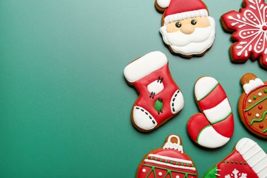 Different tasty Christmas cookies on green background, flat lay. Space for text
