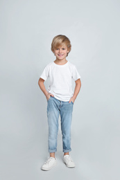 Photo of Cute little boy in casual outfit on light grey background