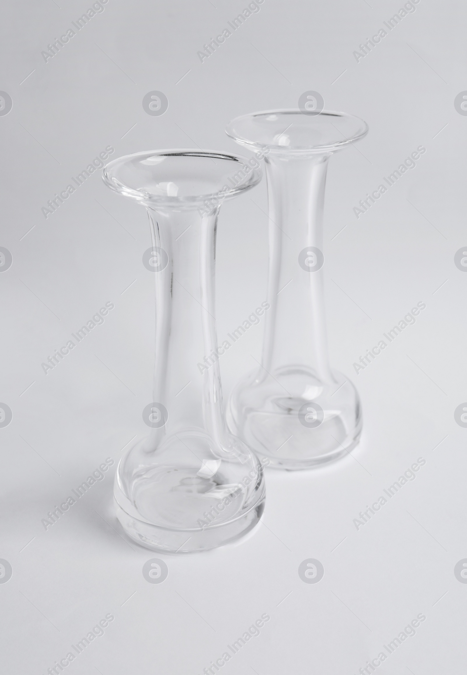 Photo of Two stylish glass vases on light background