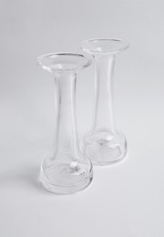 Two stylish glass vases on light background