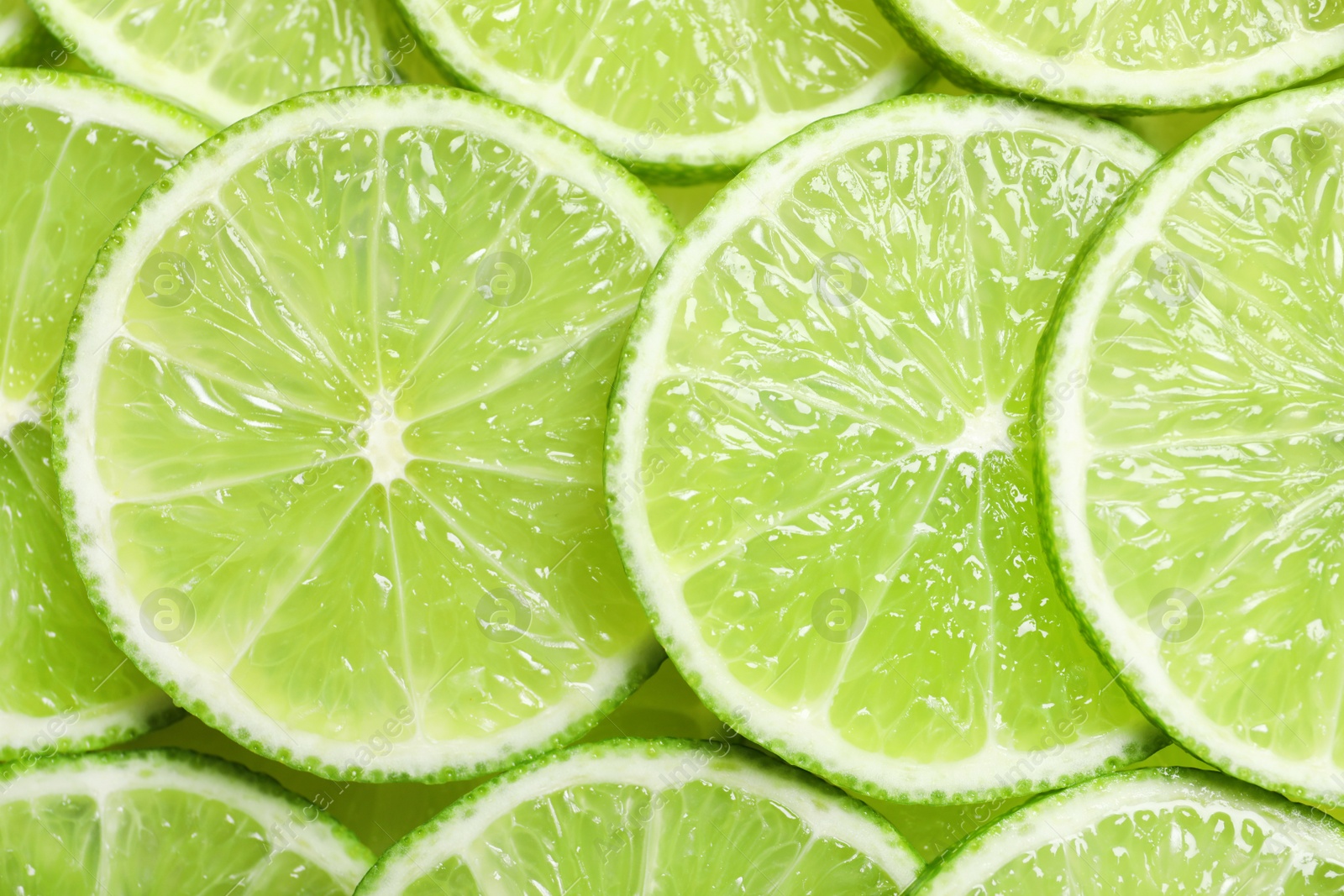 Photo of Fresh sliced ripe limes as background, top view