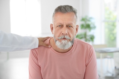 Young urologist comforting upset patient in hospital