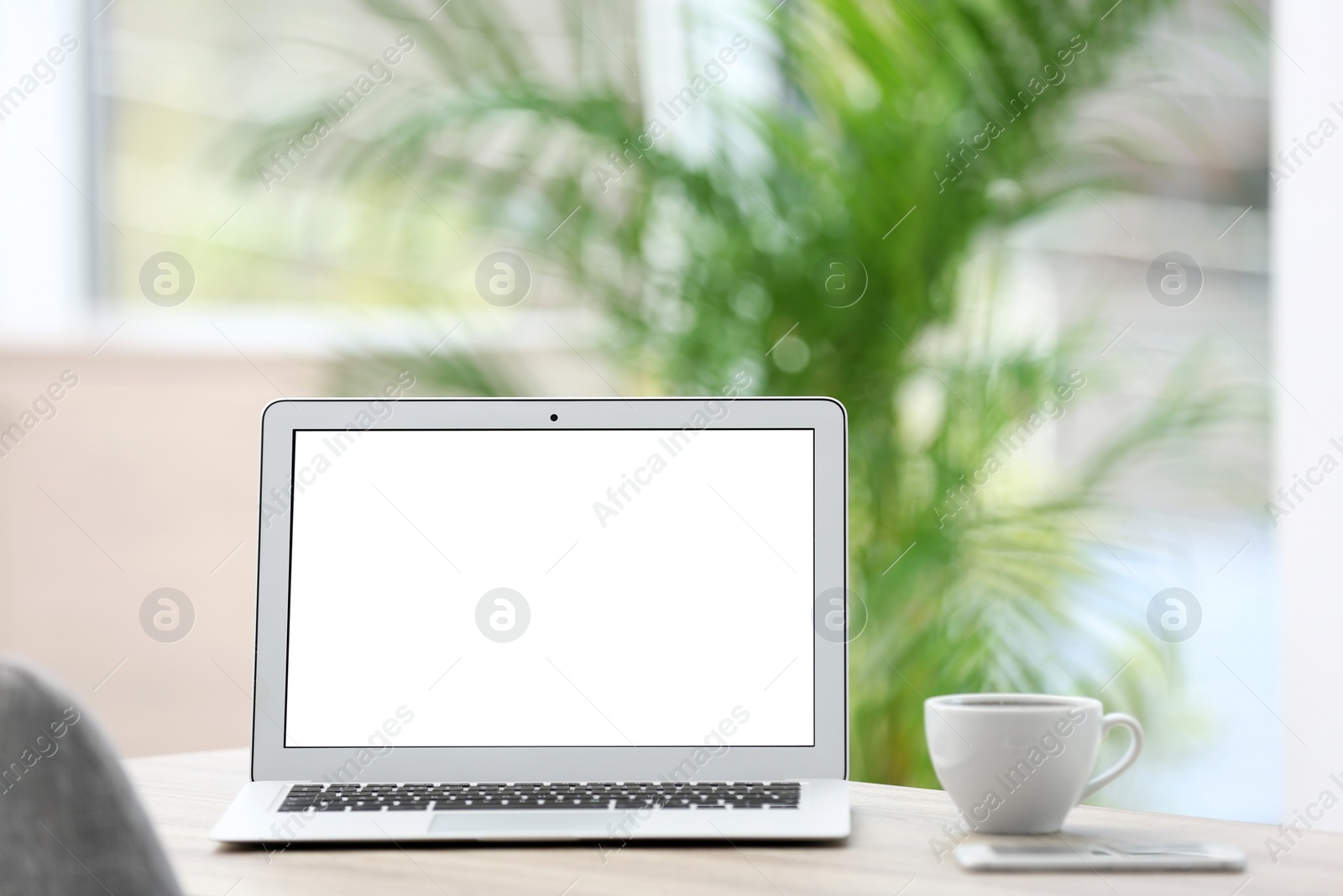 Photo of Modern laptop on desk in room. Home workplace