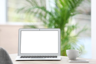 Modern laptop on desk in room. Home workplace